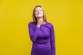 Throat pain. Portrait of unhappy ill woman suffering sore throat. indoor studio shot isolated on yellow background Royalty Free Stock Photo