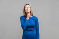 Throat pain. Portrait of unhappy ill woman suffering sore throat. indoor studio shot isolated on gray background Royalty Free Stock Photo