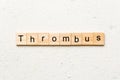 thrombus word written on wood block. thrombus text on table, concept