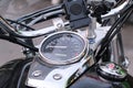 The throttle and brake on the handlebars of the motorcycle with chrome and white helmet without a visor. A white helmet hanging on