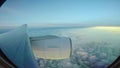 Throught plane window view of jet plane flying over cloud scape