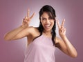 Throw sass around like confetti. a beautiful cheeky young woman showing the peace sign against a pink background.