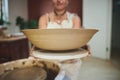 Throw your pot in the air like you just dont care. a woman making a bowl in a pottery studio.