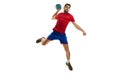 Throwing ball in a jump. Young man, professional handball player in red uniform playing, training isolated over white