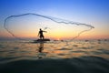 Throwing fishing net during sunrise