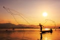 Throwing fishing net during sunset