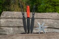 Throwing knife and Shuriken throwing star, on wooden backgroun