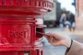 Throwing a letter in a red British post box Royalty Free Stock Photo