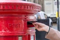 Throwing a letter in a red British post box Royalty Free Stock Photo