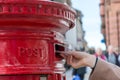 Throwing a letter in a red British post box Royalty Free Stock Photo