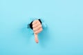 Thumb down, negative hand gesture, dislike or disagree, expression of disappointment, blue torn paper Royalty Free Stock Photo