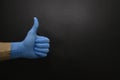 Male hand shows like in blue medical glove. The concept of positive, cleanliness and medicine. Dark background. Copy space. Royalty Free Stock Photo