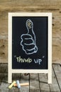 Thumb up Chalkboard Drawing on wooden background.