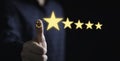 Thumb up with glowing yellow five stars for excellent evaluate after customer use product service , ISO and quality standard