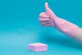 Thumb up symbol in rubber glove. pink glove on blue background