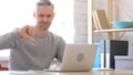 Thumbs Down by Middle Aged Man Working on Laptop