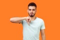 Thumbs down! Portrait of frustrated dissatisfied brunette man showing dislike gesture. isolated on orange background