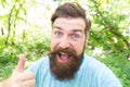 Thumbs up for bearded and beardy. Bearded man giving thumbs up hand gesture on natural landscape. Bearded hipster