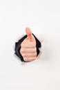 Thumbs up bursting through paper Royalty Free Stock Photo
