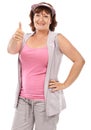 Thumbs up for cancer awareness. Mature woman wearing a breast cancer awareness ribbon against a white background. Royalty Free Stock Photo