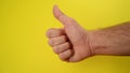 Thumbs Up For Like, male hand endorsing over yellow background