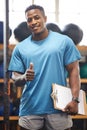 Thumbs up, portrait and fitness man in gym, clipboard and checklist for workout results, progress and like, yes or okay