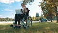 Thumbs up, Remote work concept. Young disabled woman in the wheelchair using smartphone and laptop Royalty Free Stock Photo