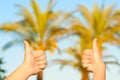 Thumbs up symbol on palm trees