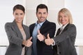 Thumbs up: three successful business people of man and woman in