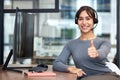 Thumbs, woman with headset and on a computer at her desk in a workplace office for success. Call center or customer Royalty Free Stock Photo