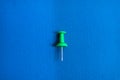 green pushpin isolated on blue Royalty Free Stock Photo