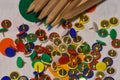 Thumbtacks and colored pencils scattered on a colored plane Royalty Free Stock Photo