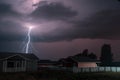 Thunderbolt over the house in the village and dark stormy sky on the background Royalty Free Stock Photo