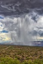 Thunderhead cloud produces rain shower over semi-desert grassland prairie Royalty Free Stock Photo