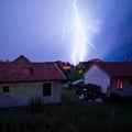 Thunderstorm above rooftops with lightning, extreme weather conditions during night, discharge of static electricity in the