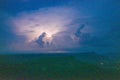 Thunderstorm cloud illuminated over mountain ridge Royalty Free Stock Photo