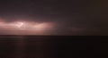 Thunderstorm with lightning over the sea at night. Lightning flashes and storm clouds Royalty Free Stock Photo