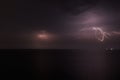 Thunderstorm with lightning over the sea at night. Lightning flashes and storm clouds Royalty Free Stock Photo