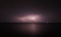 Thunderstorm with lightning over the sea at night. Lightning flashes and storm clouds Royalty Free Stock Photo