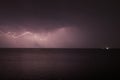 Thunderstorm with lightning over the sea at night. Lightning flashes and storm clouds Royalty Free Stock Photo