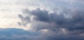 Thunderstormy sky with gray clouds, sunlight barely penetrates through the dark clouds