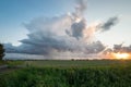Scenic view of a thunderstorm over wide open flat landscape at sunset