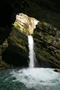 Thur waterfalls - waterfall on the rocks cascading down into a river from a sunlit hole