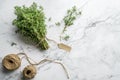 Thyme herb bunch. Bouquet of fresh thymes on light marble background with skein of jute twine. Top view Royalty Free Stock Photo