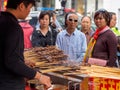 TIANJIN, CHINA - 6 OCT 2019 - Chinese customers wait for their order of Xinjiang style grilled lamb skewers at a food stall