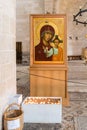 Lighted candles in front of the Icon of the Virgin and Child in the central hall in Tabgha - Catholic Church Multiplication of bre