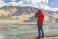 Tibet, China, June, 25, 2019. Photographer on the banks of the sacred lake Nam-TSO Nam Tso, 4718 meters above sea level Royalty Free Stock Photo