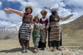 TIBET/CHINA - June 26, 2019: Smiling tibetan old women and her family in national colorful dress staying in the summer field in Royalty Free Stock Photo