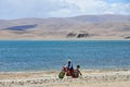 Tibet, China, June, 06, 2018. Shepherd on motorbike on the shore of lake Gomang in the summer Royalty Free Stock Photo