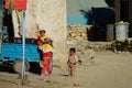 CLOSE UP: Three local Tibetan children playing in dirty streets of a rural town.